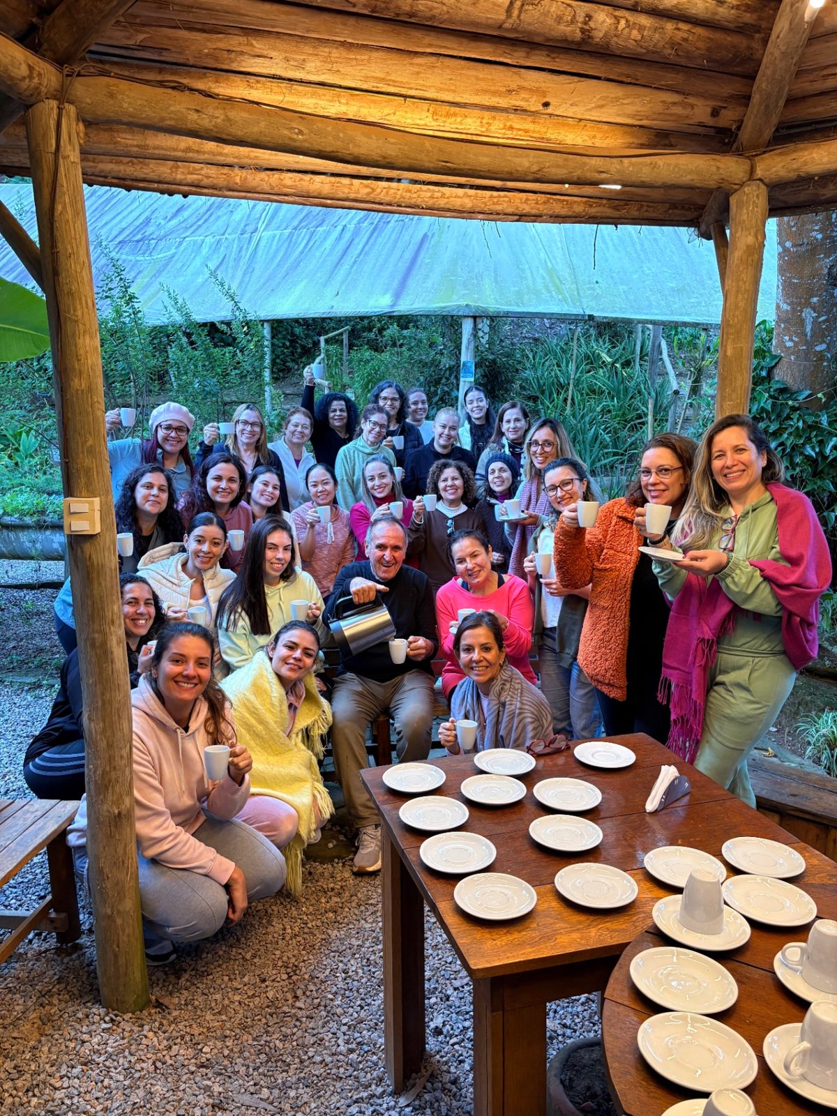 Grupo brindando com xícaras de chá no quiosque do O Bosque